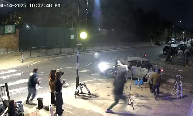 Moment thug in balaclava pulls up next to London film crew and snatches camera - before