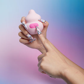 hand with long acrylic nails holding pink squish vibe from unbound